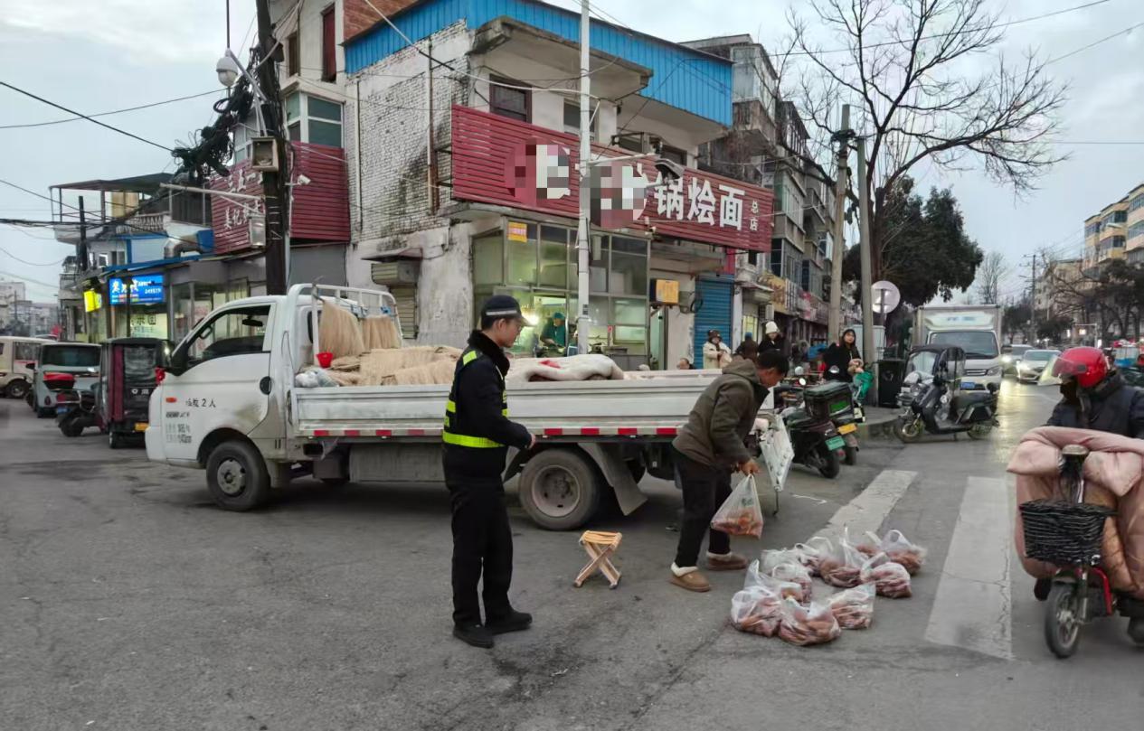 城管队员劝导流动商贩到年货销售点经营