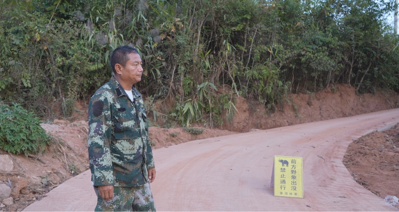 刁发兴安放告示牌，提醒村民避让