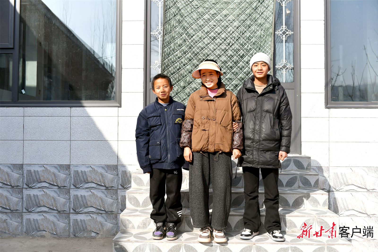 冶阿西牙和两个儿子在新居前合影