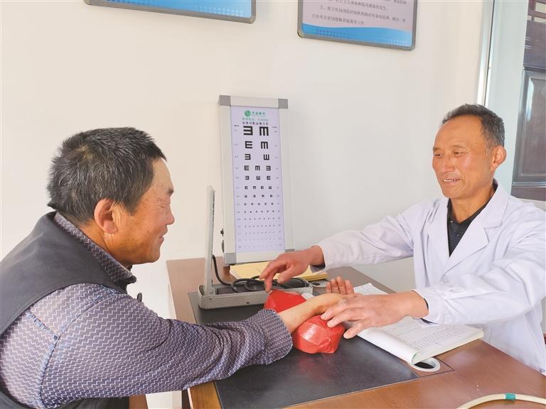 村医李峰在崭新的村卫生室问诊　刘晓芳　摄