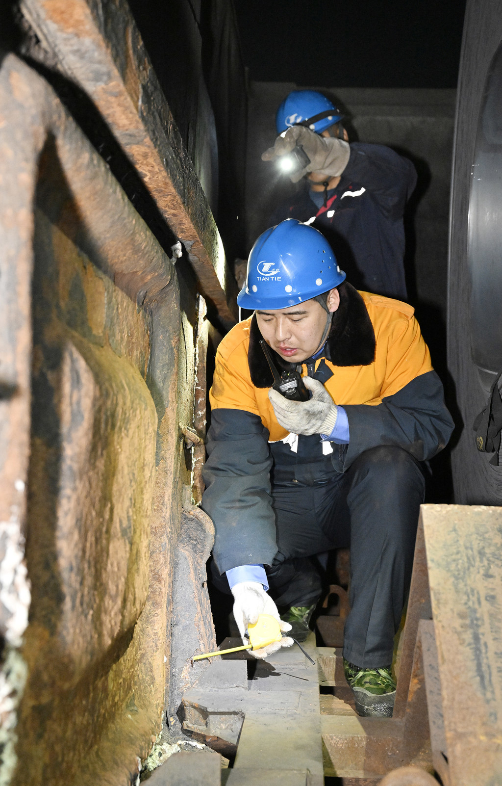 2月10日，孔明烨和工友在货车车厢测量卷钢摆放精度。