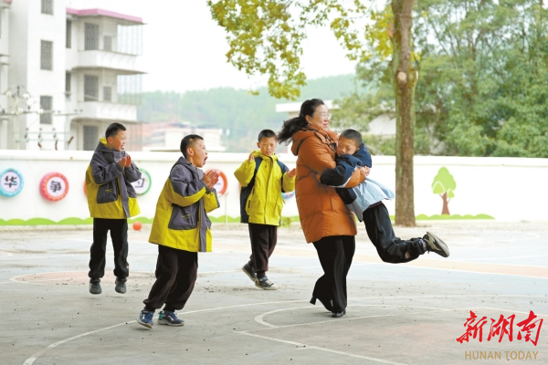 “湖南好人”黄丽娥与四胞胎在玩游戏。曹高林 摄