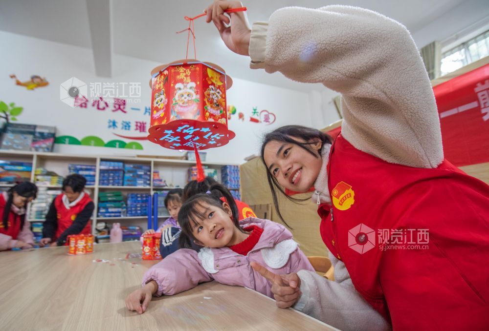 大学生志愿者在教孩子们做灯笼。