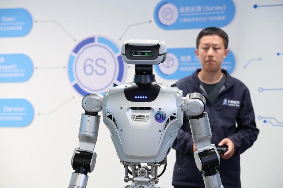 图：1月16日，在位于深圳市龙岗区的全球首家机器人6S店，工作人员展示一款具身机器人。