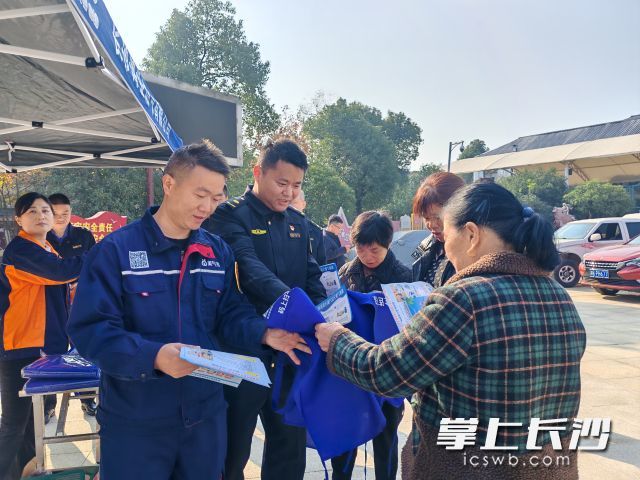 工作人员发放宣传资料，推动安全知识进社区、进家庭、进商户。
