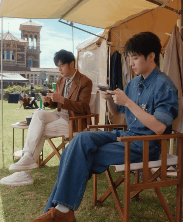 二人拿起手机打游戏，氛围融洽。