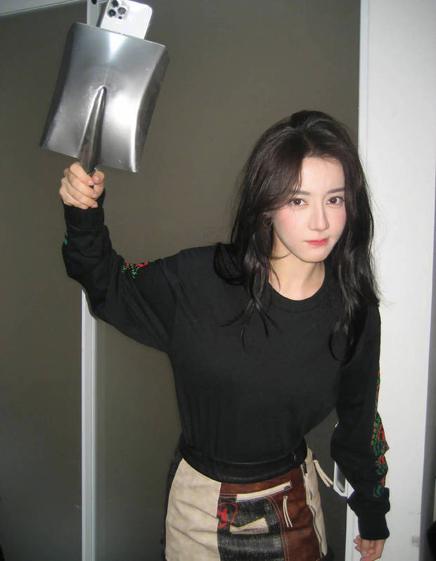 迪丽热巴用铁锨手机壳摆拍，仿佛下一秒手中的铁锨就能用作武器。