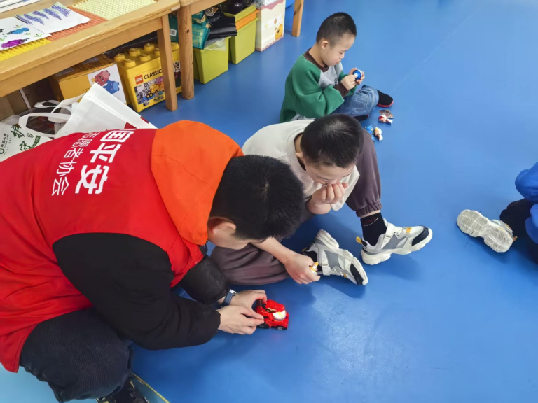 图片：志愿者与孤残儿童互动