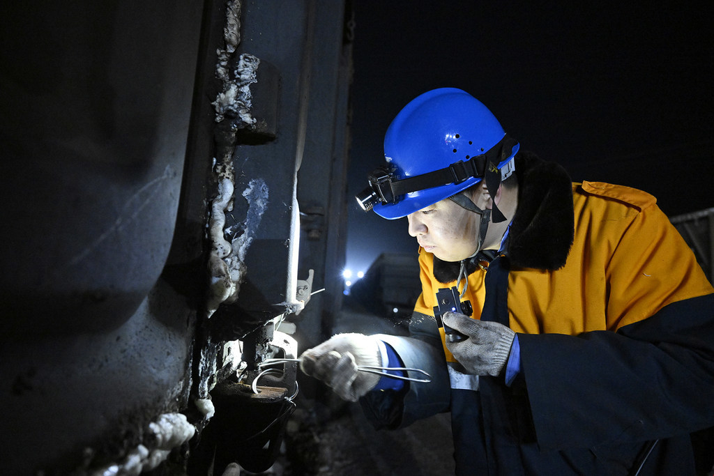 2月10日，孔明烨清理铁路货车车门残留物。