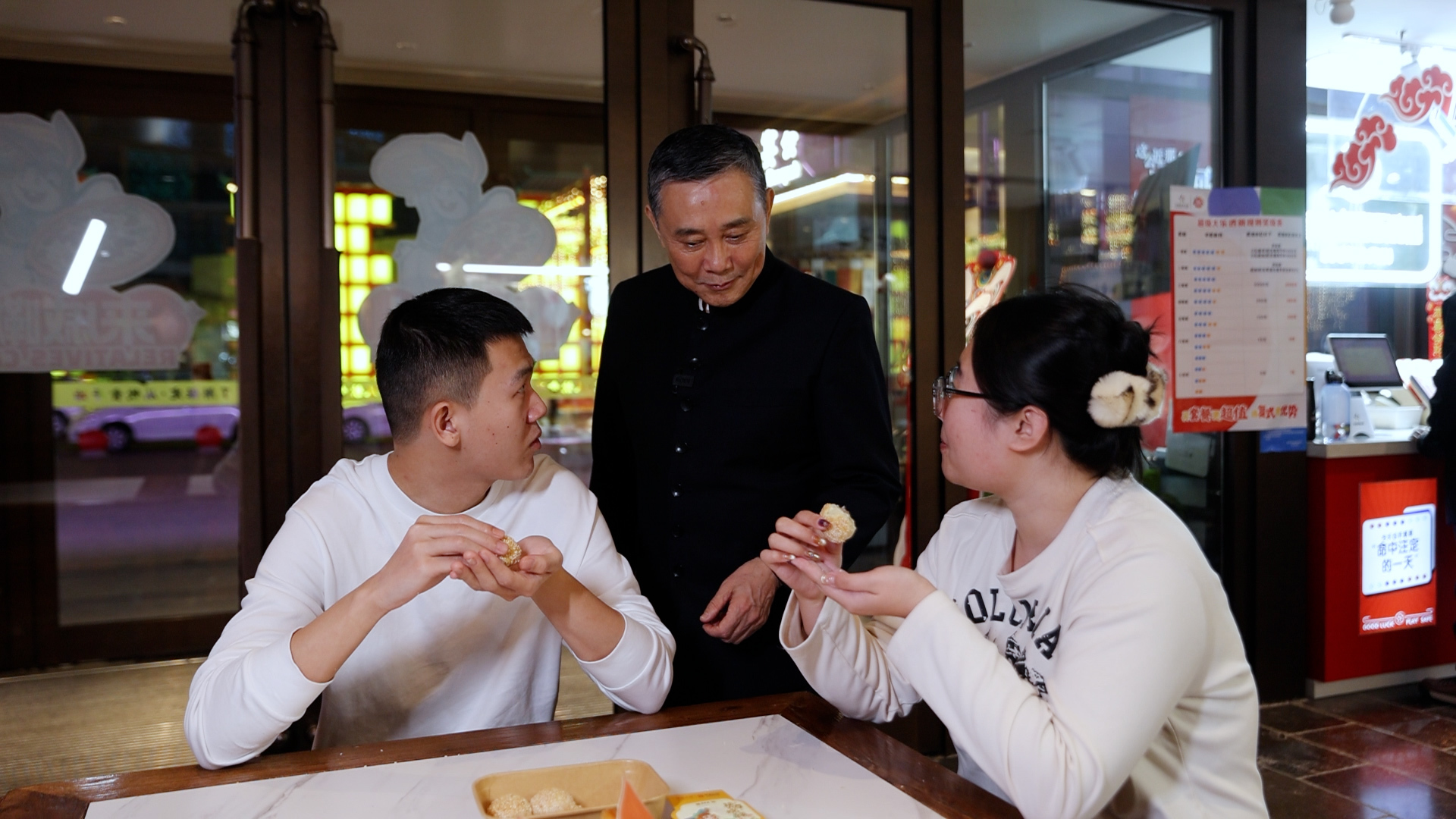 2月7日，梁连起（中）询问年轻食客对“驴肉棋子烧饼”的感受。张灵/摄