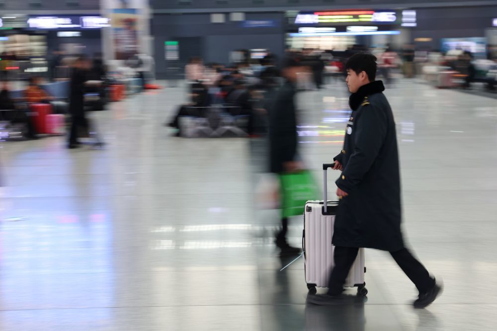 2月8日，中铁快运兰州西站营业部工作人员雒鹏将一位旅客的行李送出车站。新华社记者　陈斌　摄