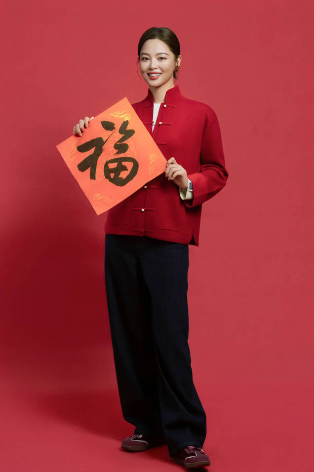 辛芷蕾手持福字站立，造型利落又喜庆。