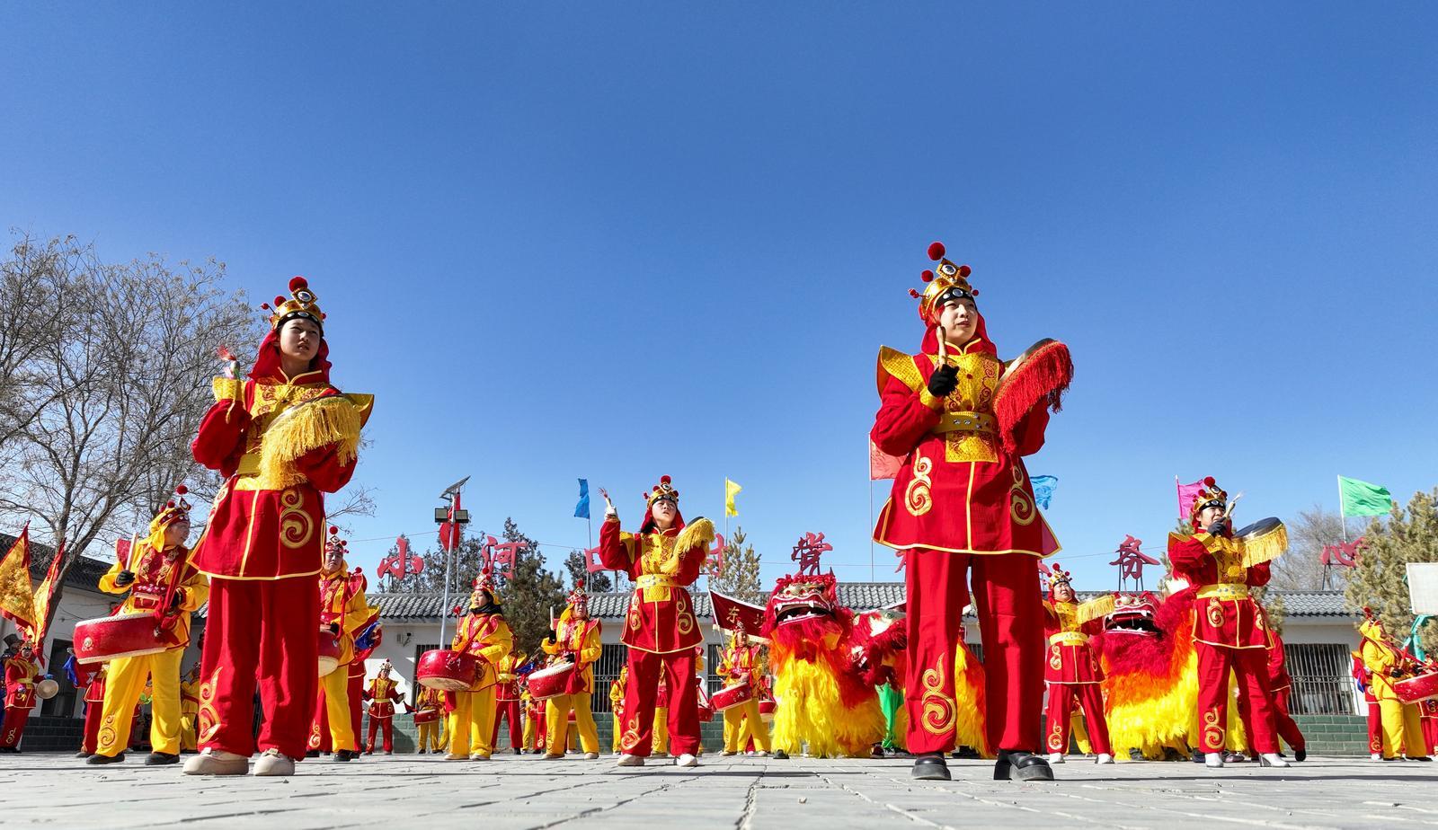 2月11日，在金塔县东坝镇小河口村社火排练现场，社火队的队员们正在排练舞狮子、打锣鼓等传统民俗文化社火，迎接即将到来的春节。