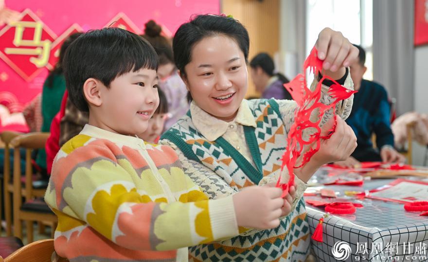 家长与孩子共剪新春窗花,指尖传递浓浓年味。