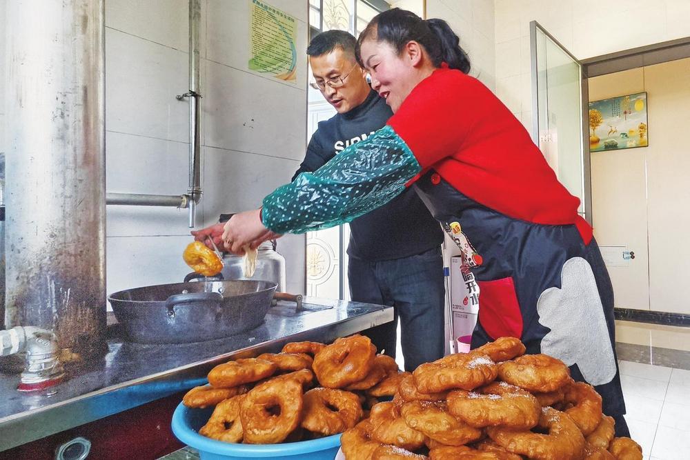 村民罗立喜一家正忙着炸油饼、做年菜