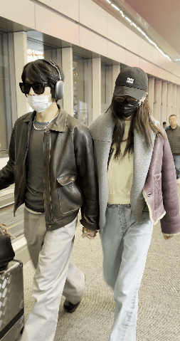 两人穿同款皮衣快步前行。