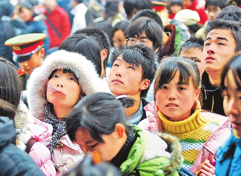 2008年1月18日，郑州火车站广场，一名女子口含车票排队进站。去年，纸质车票成为时代记忆。记者 白周峰 摄