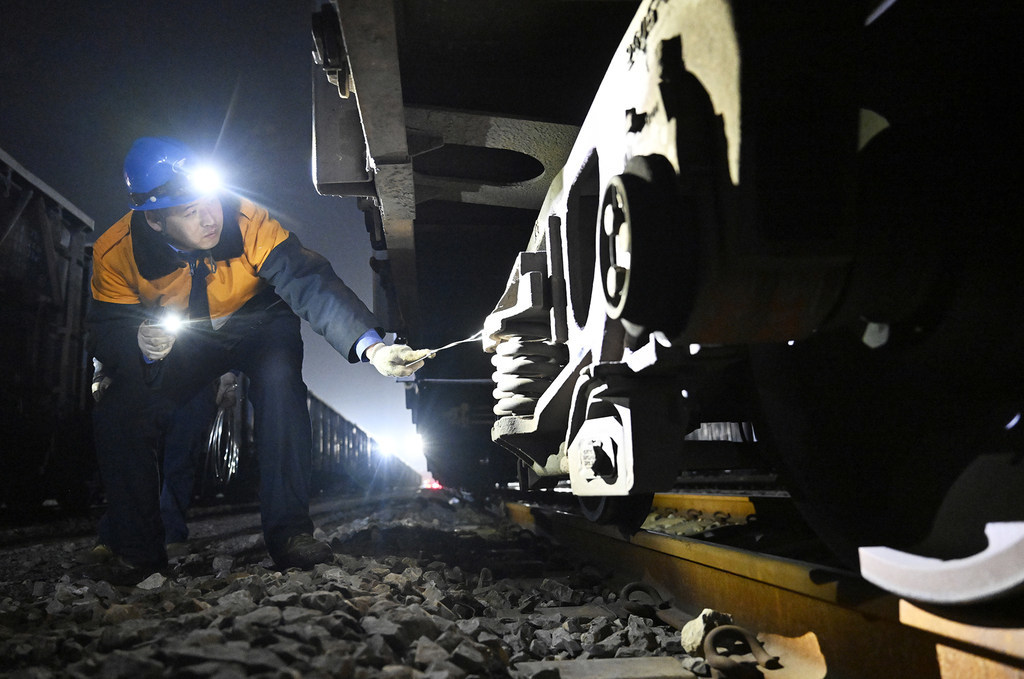 2月10日，孔明烨检查铁路货车车轮处残留物情况。