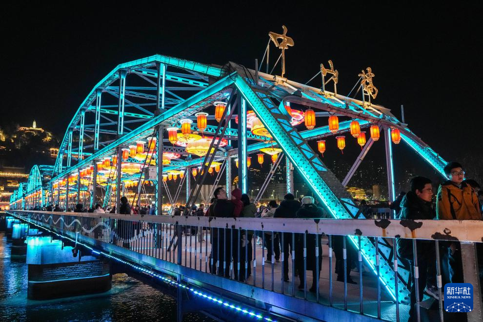 2月10日，游客在点亮新春灯饰的兰州黄河铁桥中山桥参观游览。新华社记者　郎兵兵　摄