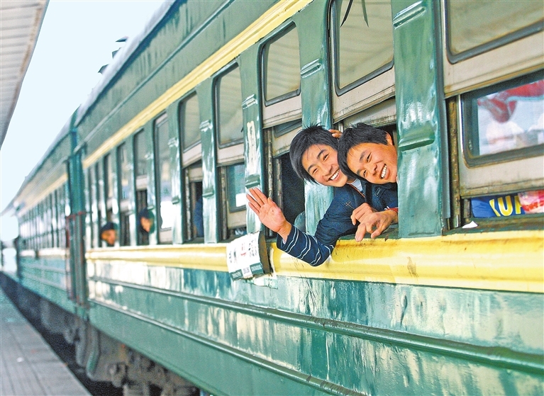 绿皮车在当年是春运的主力。2005年，几名返乡打工者在绿皮车上给记者打招呼。记者 白周峰 摄