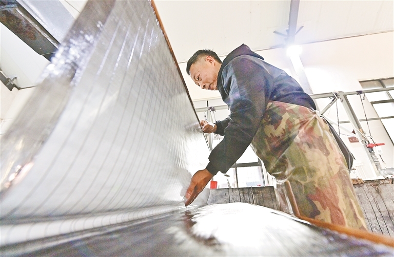 1月15日，铅山县鹅湖镇铅山连四纸发展有限公司生产基地，抄纸师傅手持特制竹帘，在纸浆槽中轻荡，让纤维均匀附于帘面。