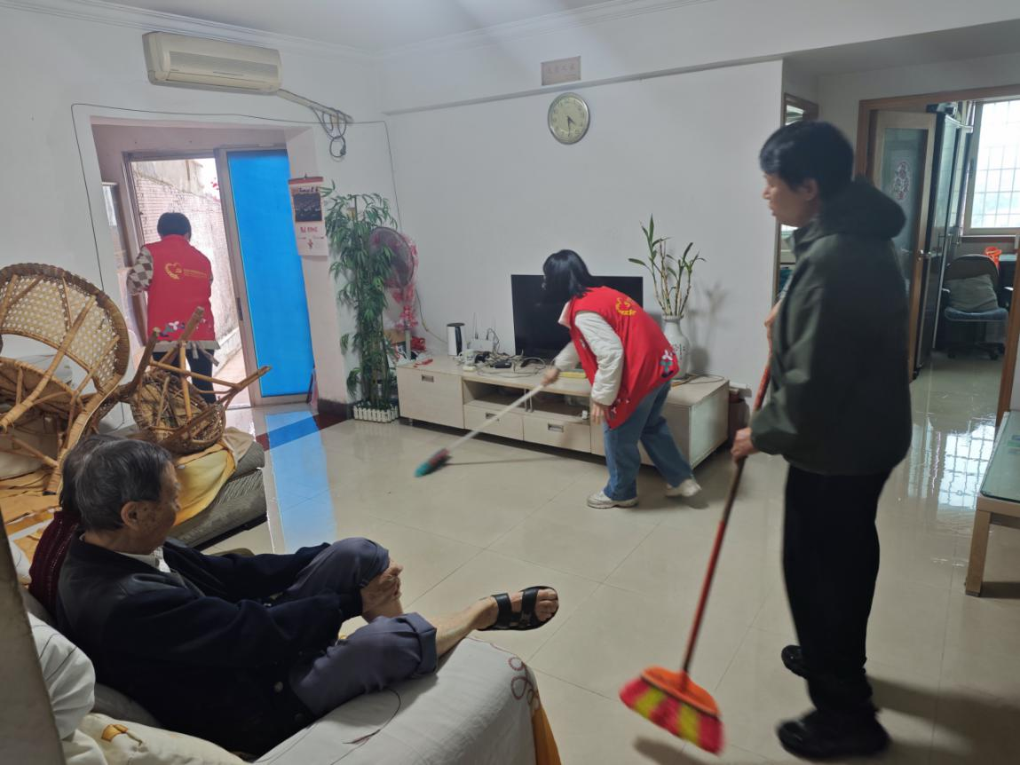 社区工作人员拿起扫帚紧急扫水