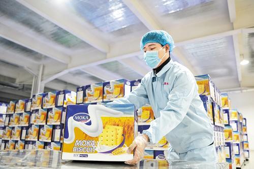 1月24日，河北津盟食品有限公司饼干生产车间，工人将装箱的饼干码垛。 本报记者 闫德见摄