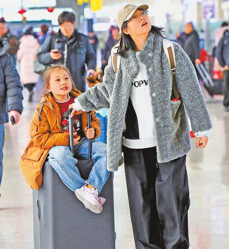 2026年2月2日，郑州东站候车大厅，一个女孩坐在行李箱上候车。记者 王铮 摄