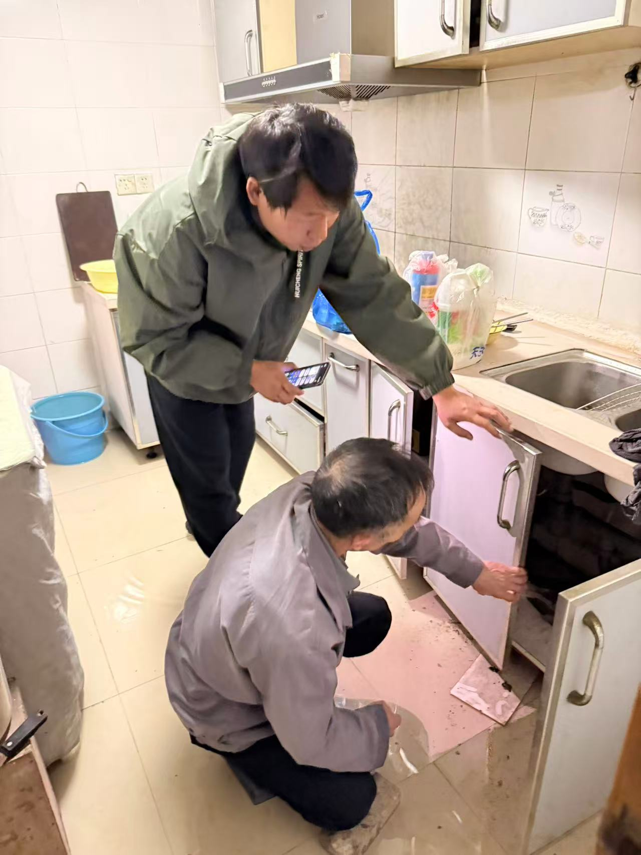 社区工作人员与物业寻找漏水原因