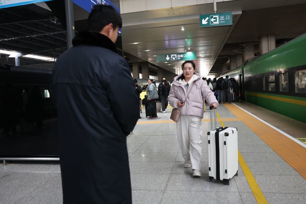 2月8日，预约“轻装行”服务的旅客石映（右）在兰州西站下车后，准备将行李交给中铁快运兰州西站营业部的工作人员雒鹏。新华社记者　陈斌　摄