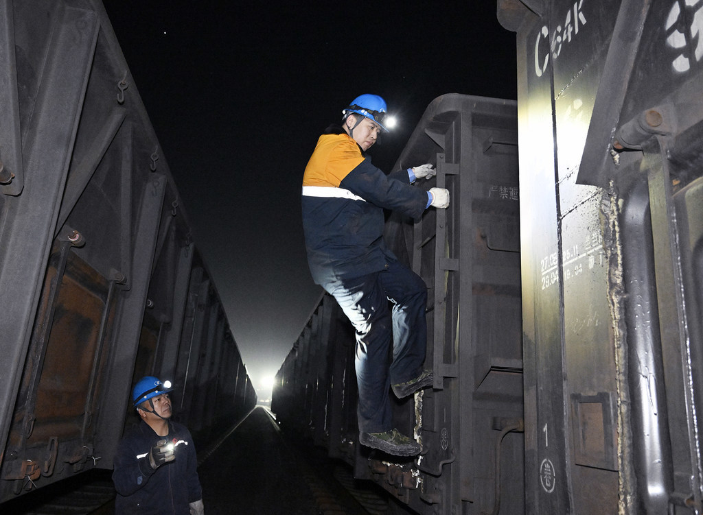 2月10日，孔明烨（右）登车检查卸空车辆的安全隐患。