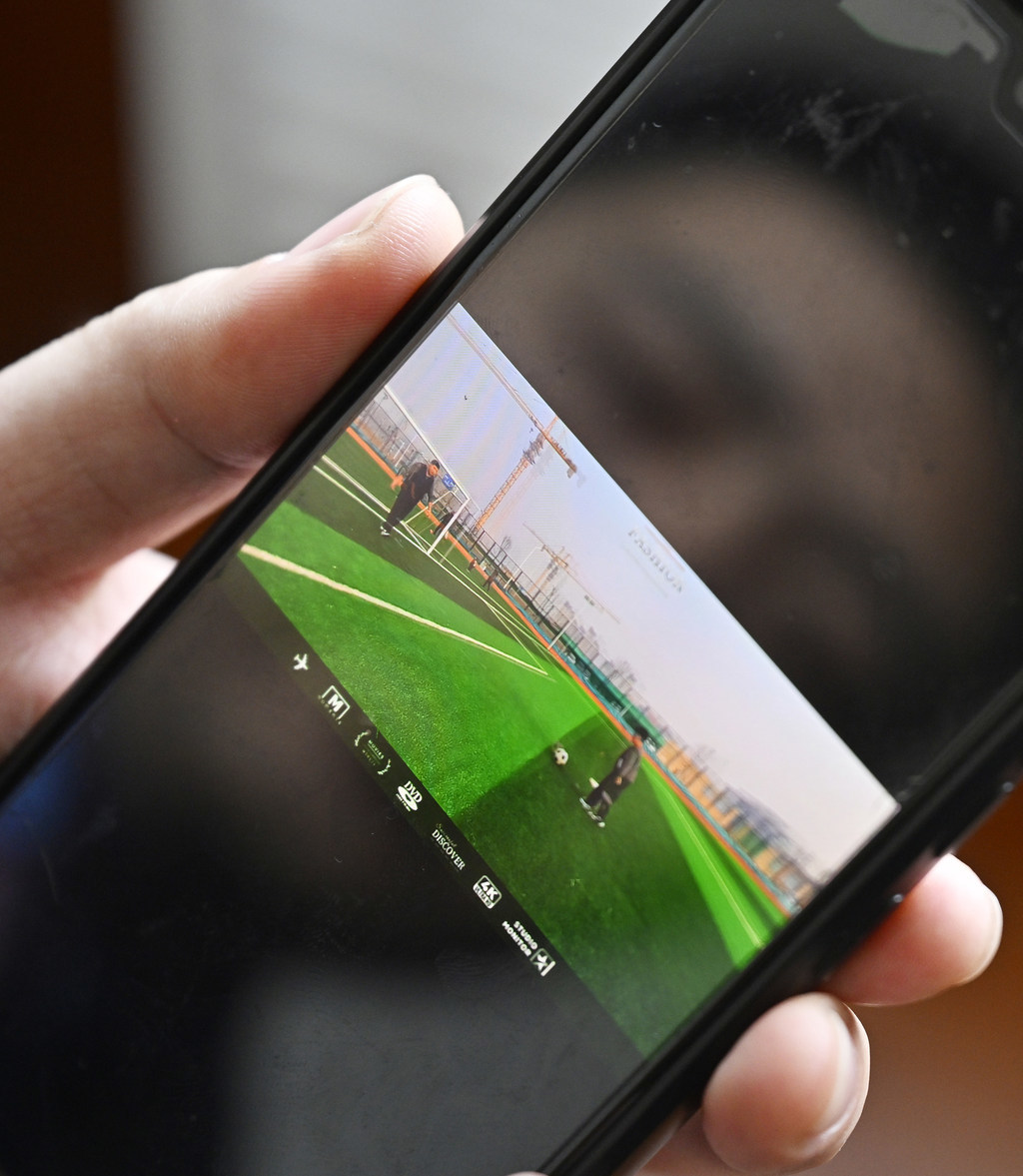 2月10日，孔明烨向记者展示手机里他和儿子踢足球的视频。