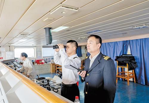 近日,唐山港引航员陆政祥(右一)、易柳堤(右二)正在指引外籍货轮靠泊。本报记者赵 杰摄