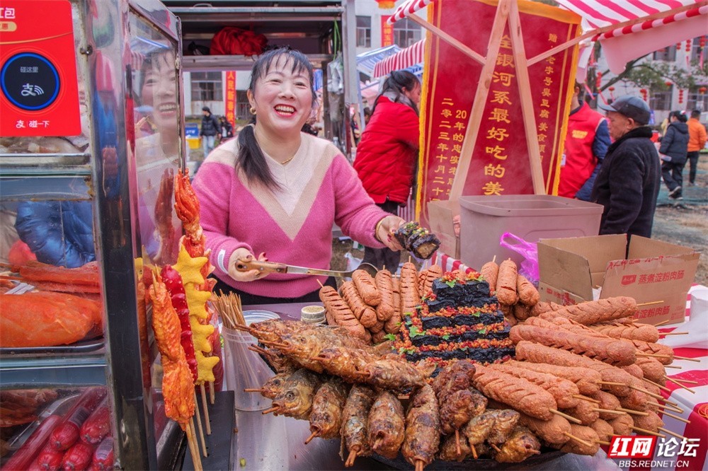 @谭学文：顶级年味藏在湘潭县这个小镇的油锅里，油锅里的火焰滋滋作响，琳琅满目的小吃串成了喜庆的红色，摊主大姐脸上的笑容比红灯笼更灿烂。