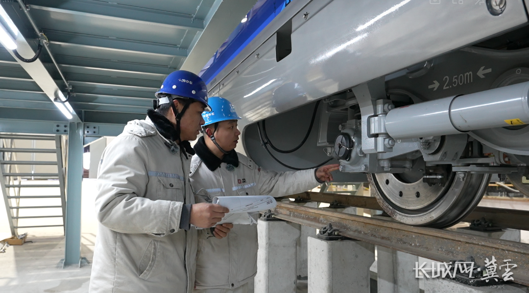 中车四方股份京雄快线列车维保班组组长李旺和同事正在对车辆进行列检。杨程 摄