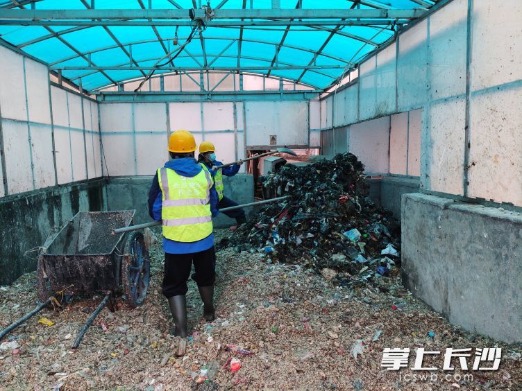 站长龙珑和值班员秦雅雯清理垃圾。