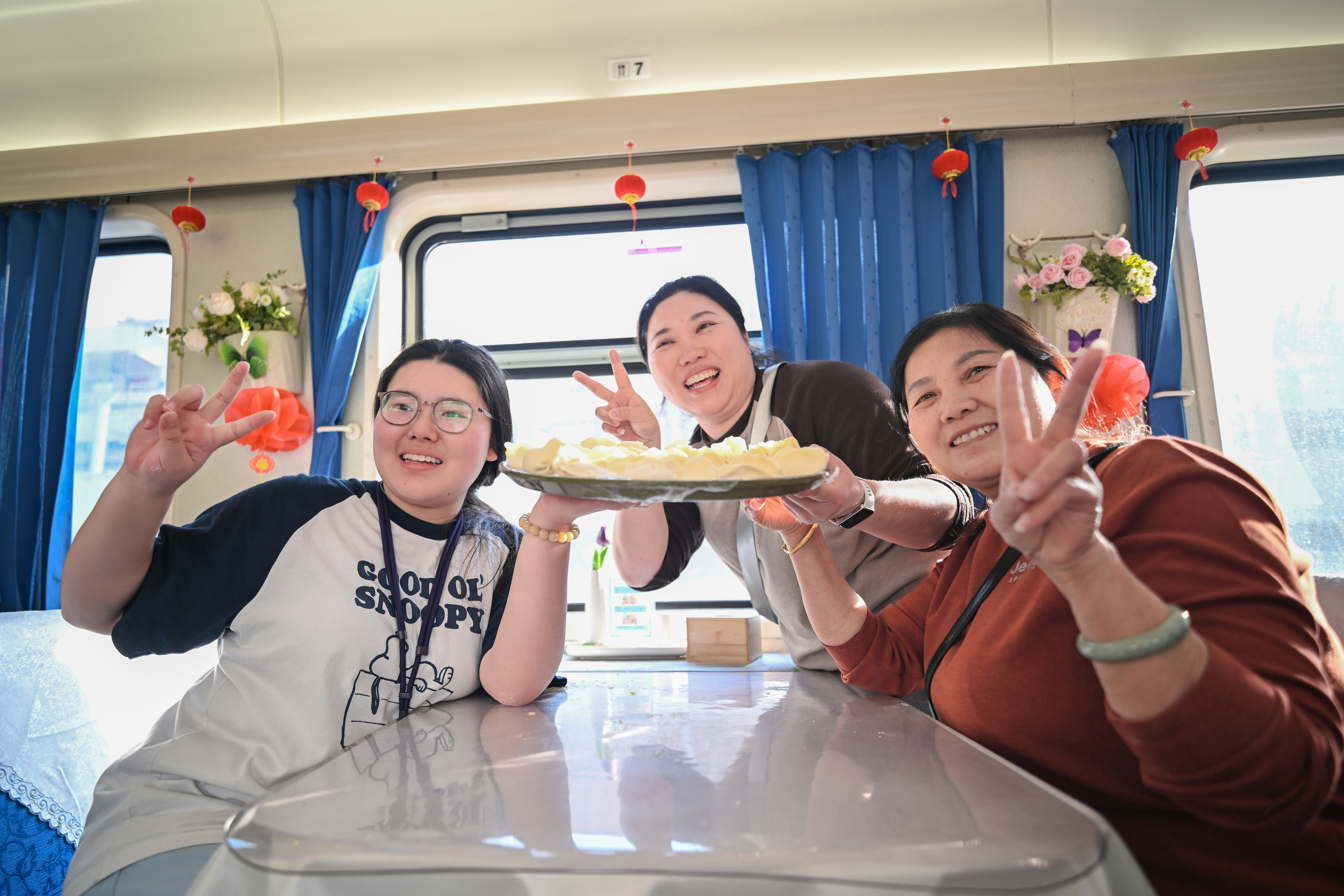 旅客在列车上一同包饺子庆祝春节