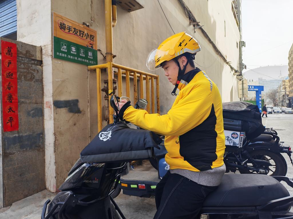 杨文涛正在手机上查看外卖订单配送情况　新华社记者　崔翰超　摄