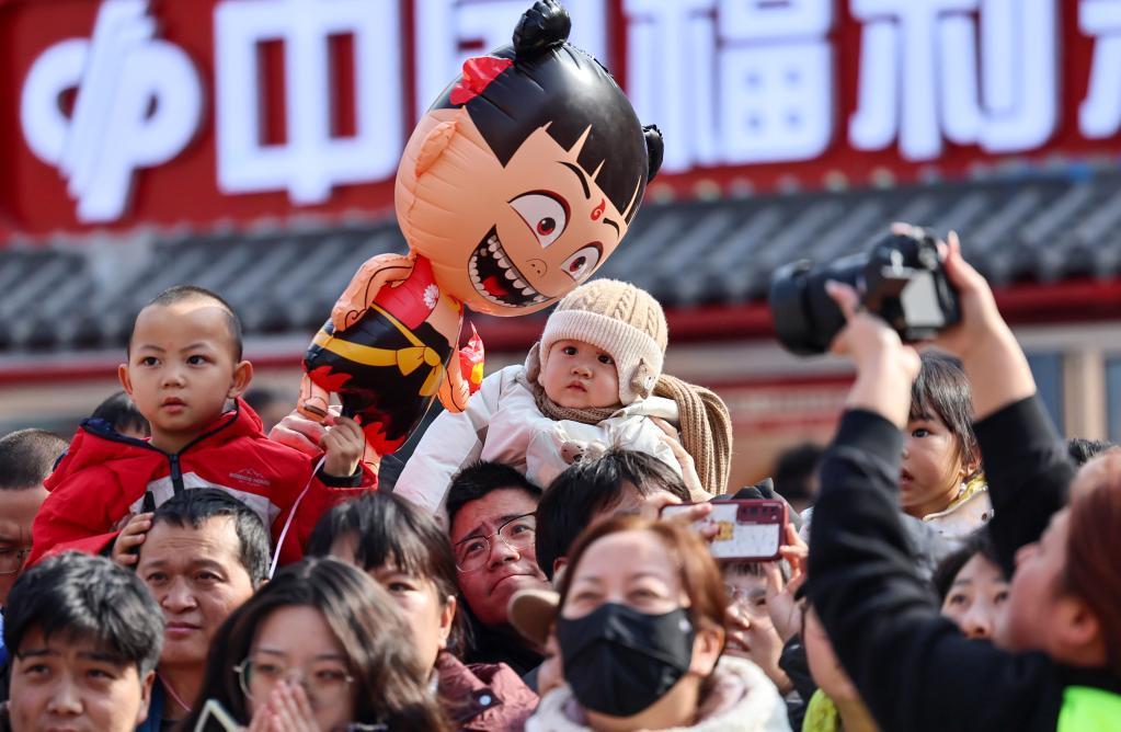 2月18日，小朋友在甘肃省兰州市七里河区兰州老街民俗演出现场观看表演。新华社发（侯崇慧　摄）