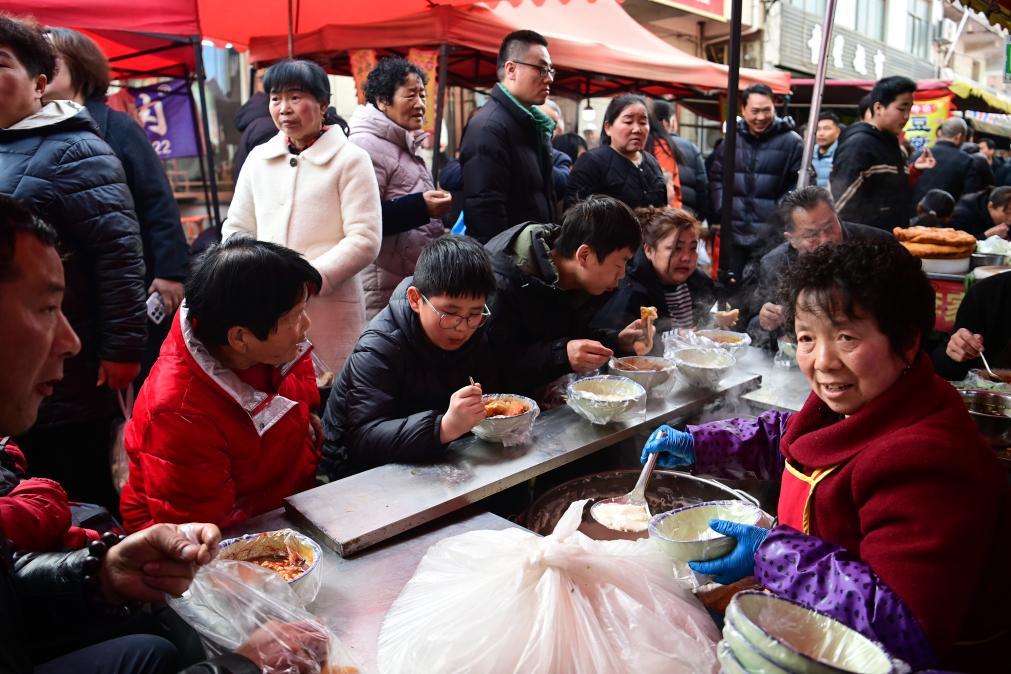2月13日，游客在焦岱大集上品尝特色小吃。