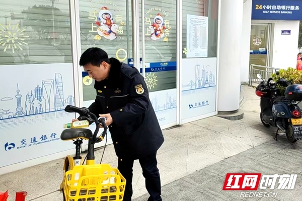 城管工作人员对未按规定停放的电动车逐一规范摆放。