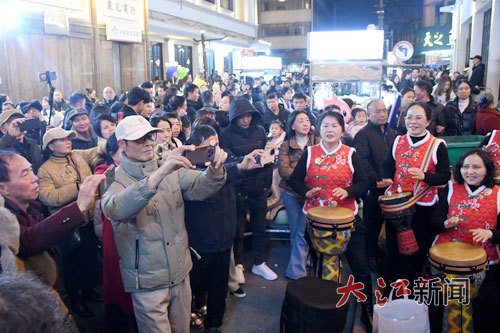 2月18日晚，抚州市南丰县南门古城老街热闹非凡，游客们正欣赏南丰傩舞、非洲鼓、古筝等表演。大江网视觉江西 袁荣生 摄