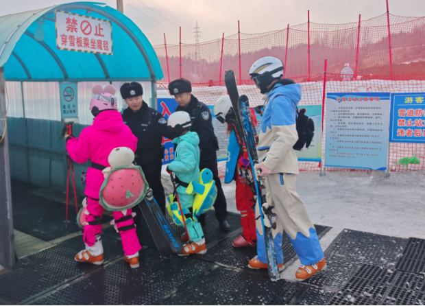 郑守鑫（左）在滑雪场入口引导游客安全通行