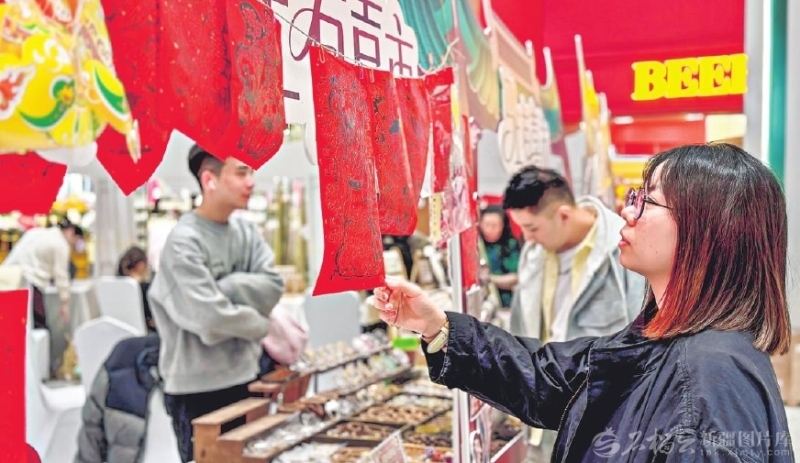 2月23日,顾客在乌鲁木齐CCMALL时代广场非遗集市上挑选福字。这里不仅延续着节日购物的火热氛围,更因一场别开生面的非遗集市,吸引了众多消费者驻足体验。春节假期,乌鲁木齐市消费市场活力迸发,年味与烟火气交织升腾。石榴云/新疆日报记者 李瑞摄