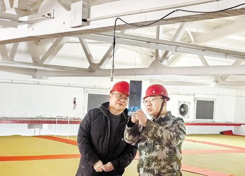 2月14日，在河北开源粮油储备库有限公司，田军（左）和胡保岩查看粮仓温度。 本报记者 贡宪云摄