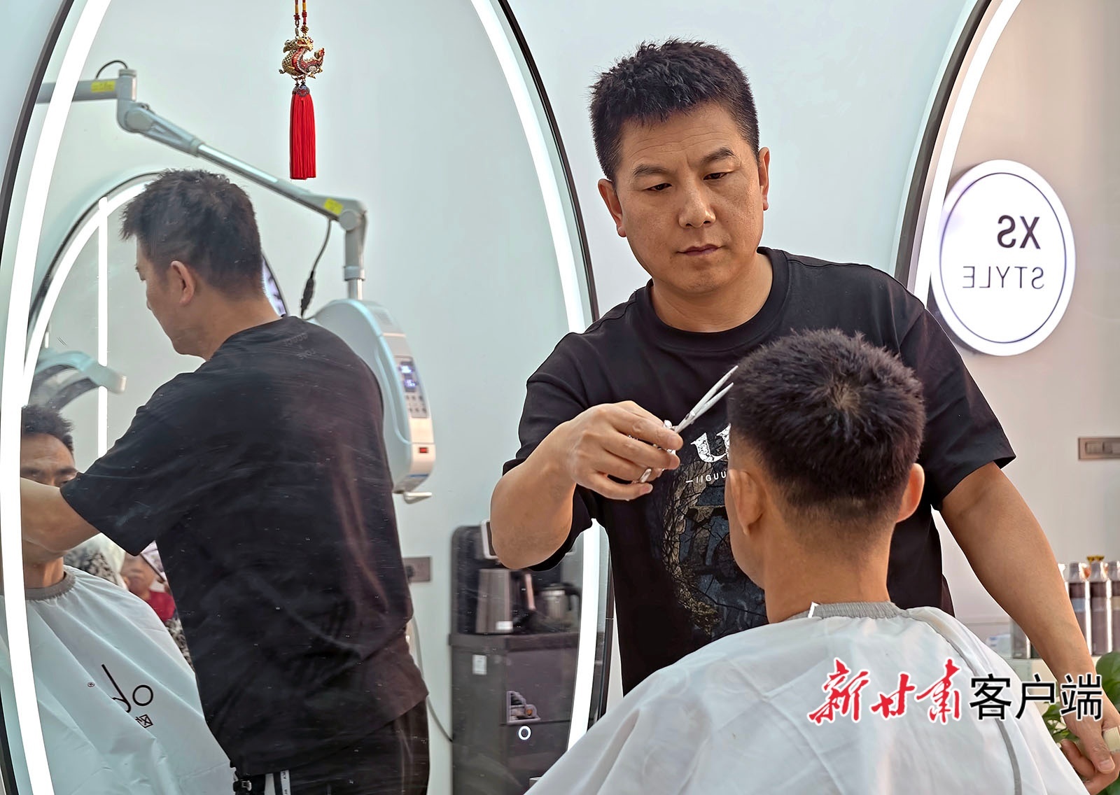 2月24日,西峰区一家理发店恢复营业,发型师为顾客剪发。