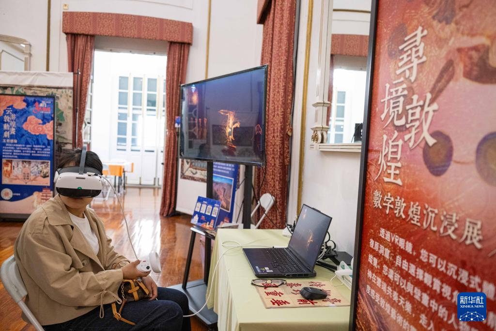 2月20日,市民在敦煌文化周活动的“寻境敦煌”环节通过VR眼镜沉浸式探索莫高窟。新华社发(张金加 摄)