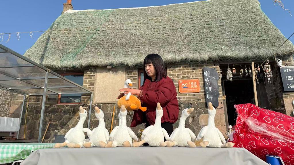 刘晓杰在其工作的咖啡馆门口摆放大天鹅玩偶。新华社记者 李志浩 摄