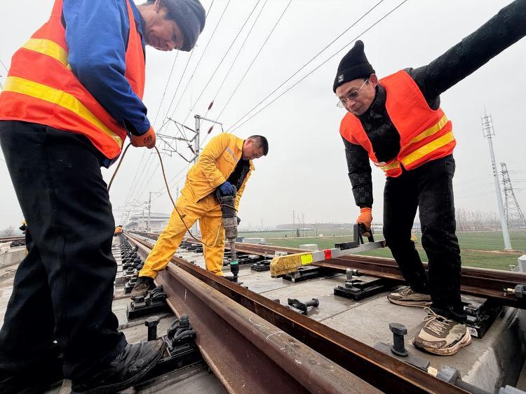 2月26日，在雄商高铁聊城至菏泽区段静态测试现场，工人们正进行精调精修作业。新华社记者 张钟仁 摄