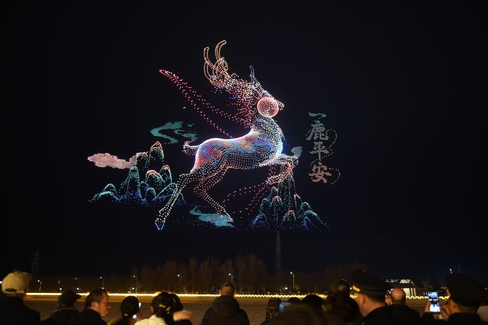 2月22日晚，人们在甘肃省敦煌市党河风情线观看无人机光影秀。新华社发（高宏善　摄）